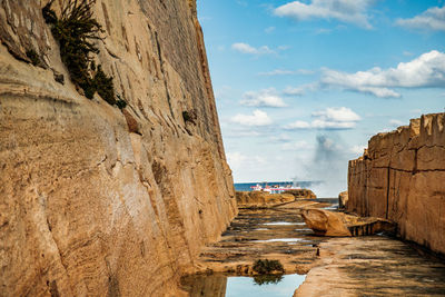 Rock formation amidst sea against sky