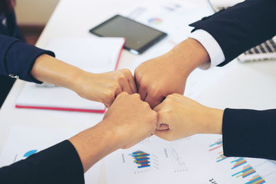 Low angle view of people hands on table