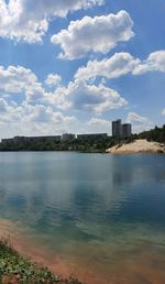 Scenic view of lake by buildings against sky