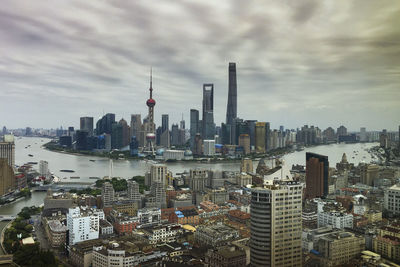 Modern buildings in city against cloudy sky