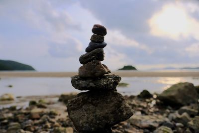 Stack of stones on beach against sky