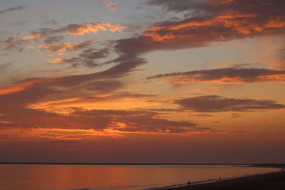 Scenic view of sea against dramatic sky during sunset