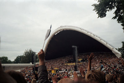 People enjoying at music concert against sky