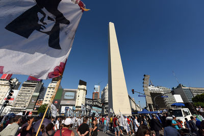 Group of people in front of buildings against sky