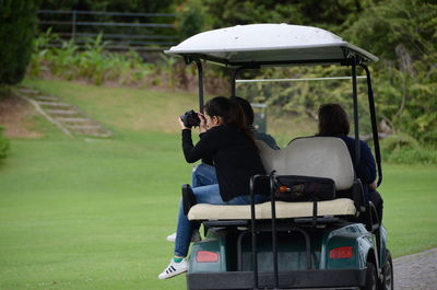 Rear view of people sitting on field