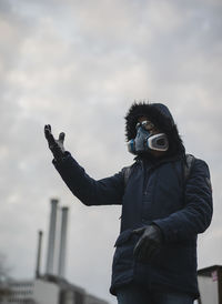 Man with mask photographing against sky after corona influenza in berlin 2020