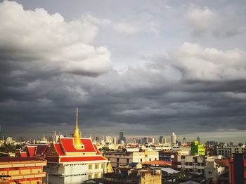 View of cityscape against cloudy sky