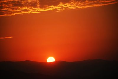 Scenic view of silhouette mountain against romantic sky at sunset