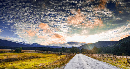 Road amidst landscape against sky during sunset