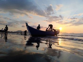 Silhouette boat in sea against sky during sunset