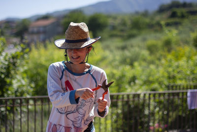 Woman wearing hat standing against coltivated field