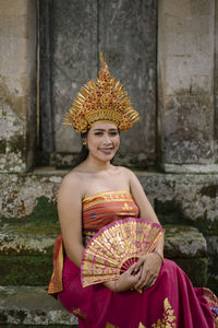 Portrait of young woman wearing traditional clothing sitting on steps
