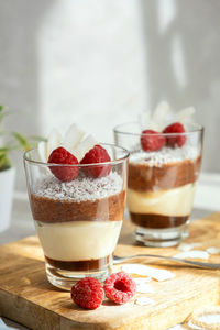 Three-layer mousse dessert made of chocolate and vanilla, decorated with fresh raspberries 