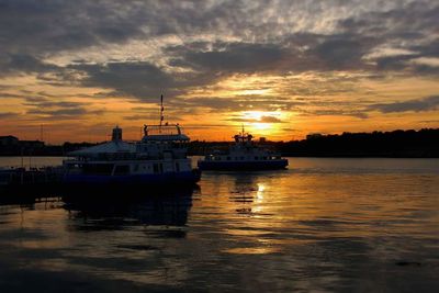 Boats sailing in river during sunset