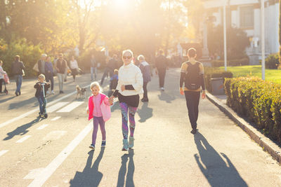 Full length of mother and daughter walking on street 