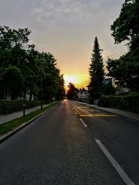 Road by trees against sky