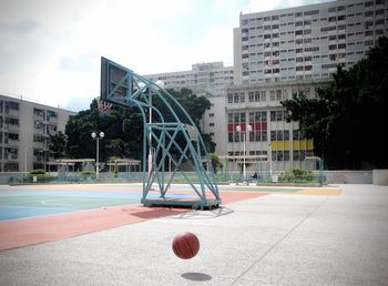 View of basketball court against buildings in city