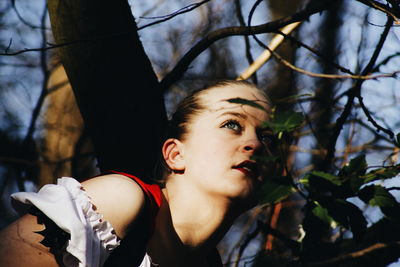 Close-up of young woman against tree