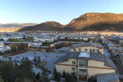 High angle view of houses and lake against clear sky