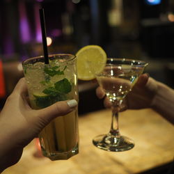 Cropped hand of people toasting drink in glass