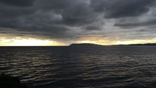 Scenic view of sea against storm clouds