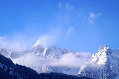 Scenic view of snowcapped mountains against blue sky