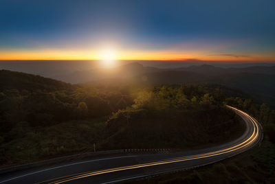 Road and mountains against sky during sunset