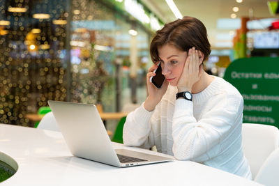 Young woman using laptop at cafe