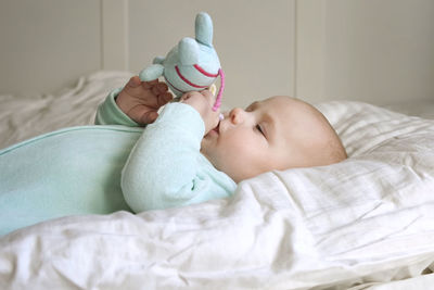 Portrait of cute baby boy sleeping on bed at home