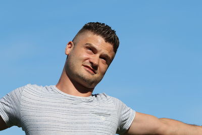 Portrait of young man against clear blue sky