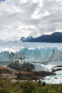 Scenic view of sea and snowcapped mountains against sky