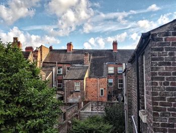 Houses in town against cloudy sky