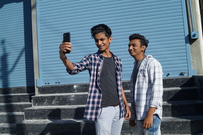 Portrait of young man standing against wall