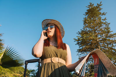 Low angle view of woman standing against sky