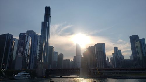 Modern buildings in city against sky during sunset