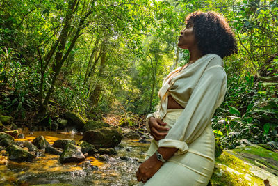 Side view of young woman in forest