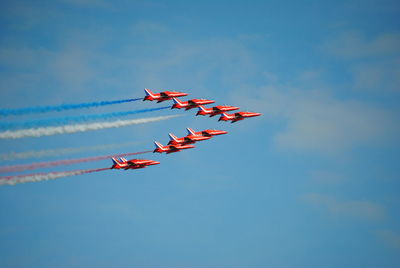 Low angle view of fighter planes flying against sky during airshow