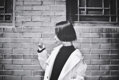 Boy standing against brick wall