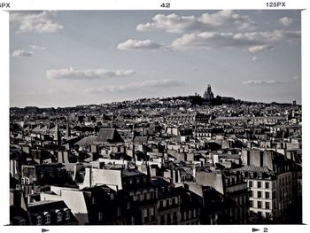 Cityscape against cloudy sky