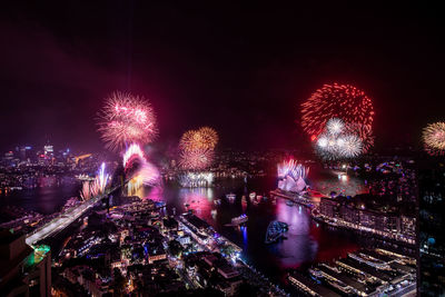 Firework display in illuminated city at night