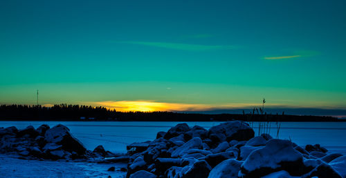 Scenic view of frozen lake against sky during sunset