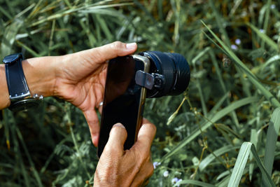 Cropped hand of man holding camera