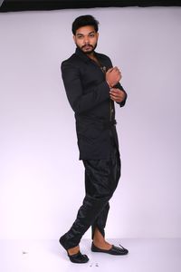 Portrait of young man standing against white background