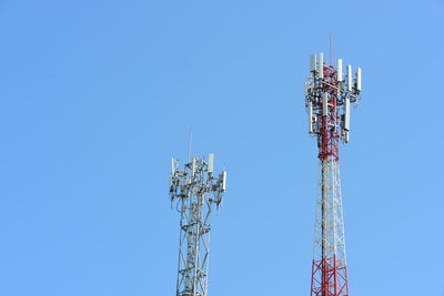 Low angle view of communications tower against clear blue sky