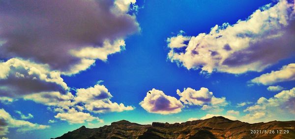 Low angle view of mountain against blue sky