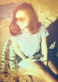 Woman wearing sunglasses sitting outdoors