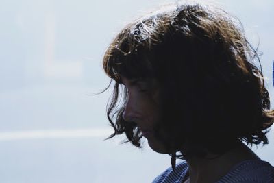 Close-up of thoughtful woman with short hair against sky