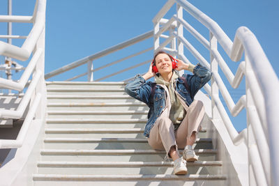 Full length of young woman standing on staircase