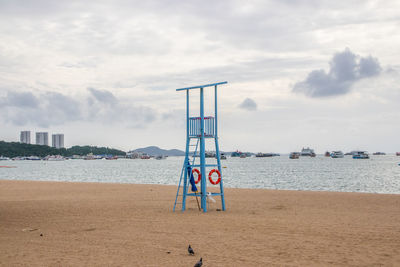 Lifeguard hut on beach against sky