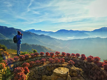 Man standing on mountain against sky